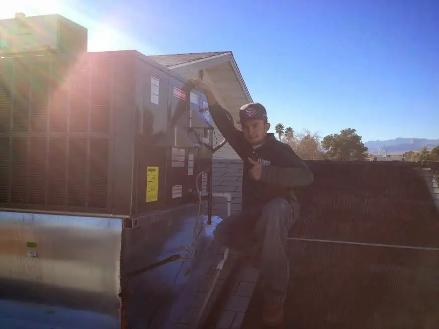 HVAC technician performing Heat Pump Repair on a rooftop unit in East Alton